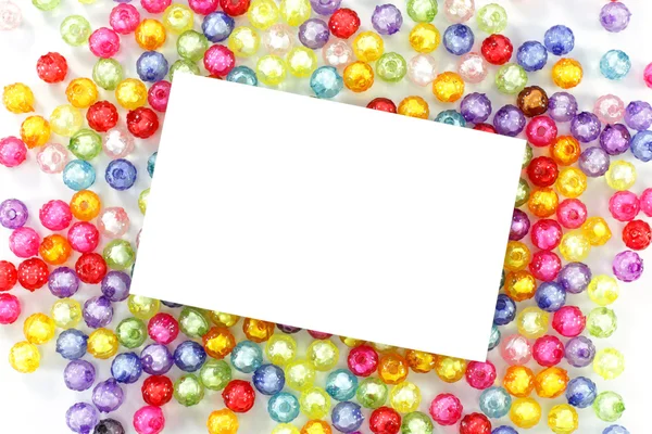 Empty white paper on colorful beads on white background — Stock Photo, Image