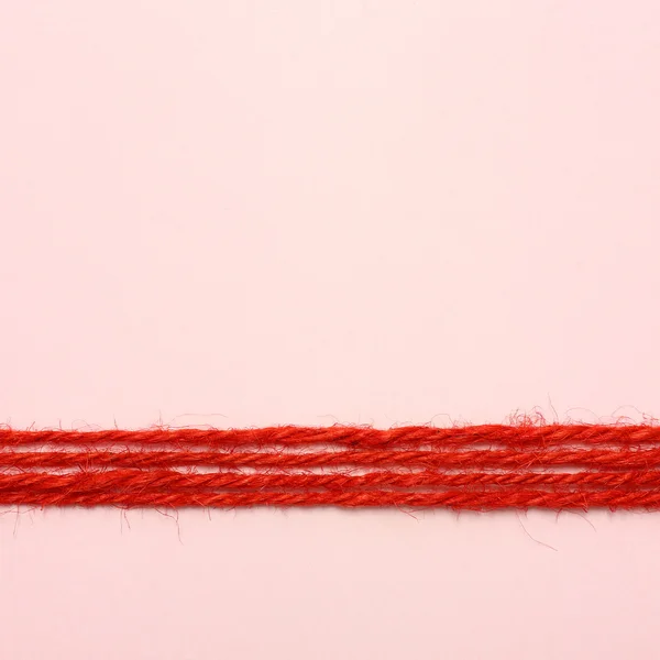 String vermelho como moldura no fundo rosa — Fotografia de Stock