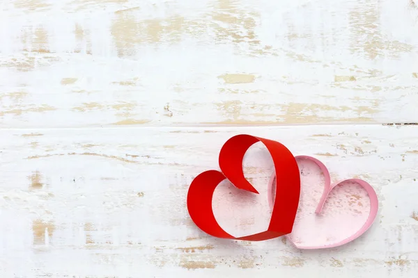 Coeur en papier rouge et rose sur fond de bois blanc — Photo