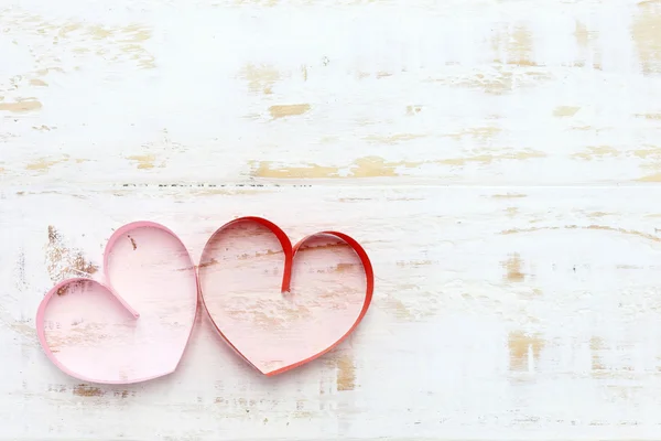 Rosso e rosa cuore di carta su sfondo di legno bianco — Foto Stock