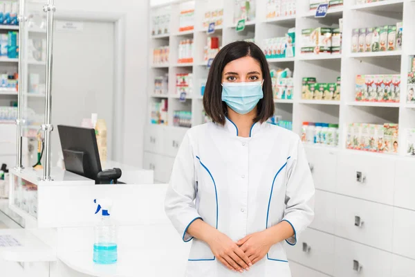 Jovem farmacêutico turco feminino com máscara médica em pé na frente do balcão na farmácia — Fotografia de Stock