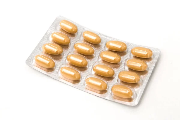 Bolha closeup com pílulas naturais eco antivirais marrom medicina no fundo branco. protecção contra a gripe sazonal — Fotografia de Stock