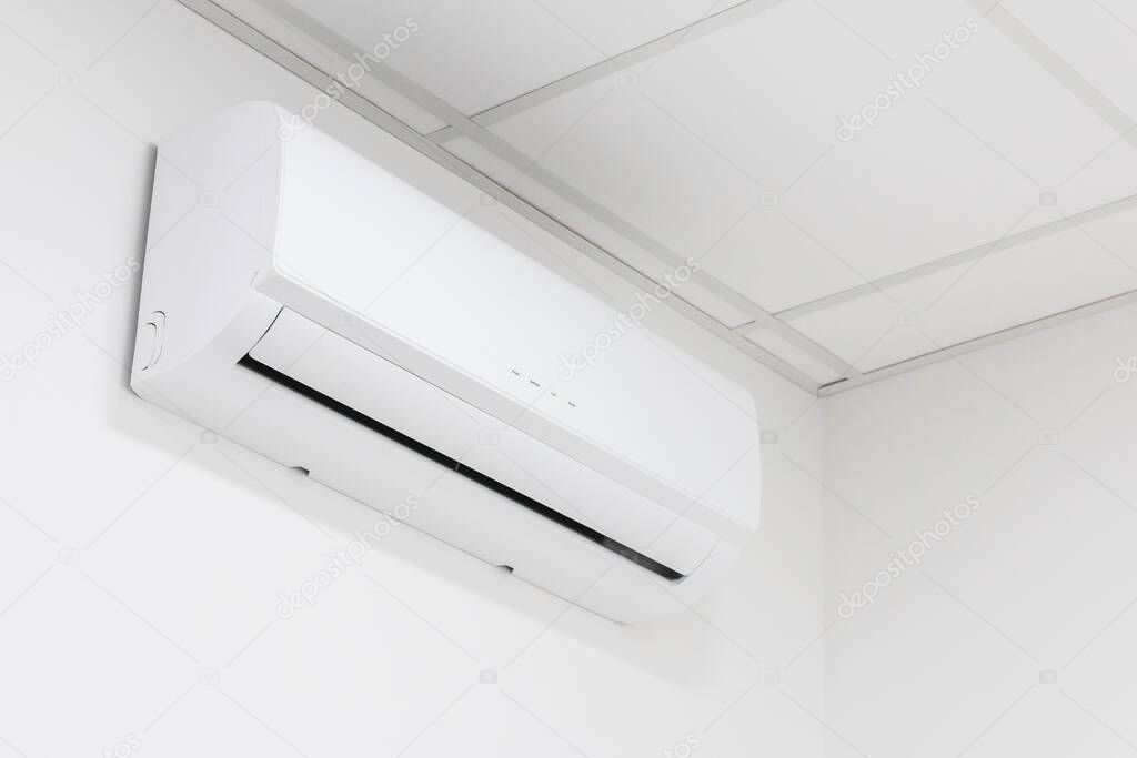 white heating and cooling air conditioner on white wall in office or home