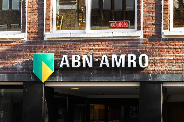 Utrecht, Holanda, 24 de janeiro de 2021: ABN Amro bank closeup inscription on a building and the word work red-lit above it — Fotografia de Stock