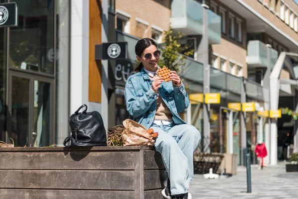 Hermosa morena 20-30s disfrutando de deliciosa comida para llevar restaurante en la calle en el almuerzo — Foto de Stock