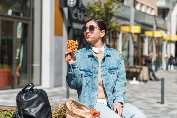 Chica atractiva comer con gran placer sabrosa comida de llevar café en la calle. te lo mereces — Foto de Stock