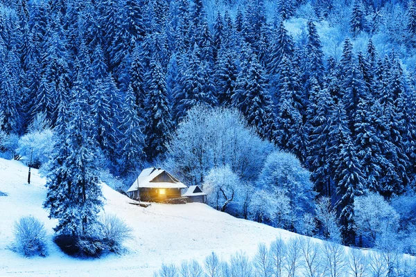 Wooden hut with a lighted window — Stock Photo, Image