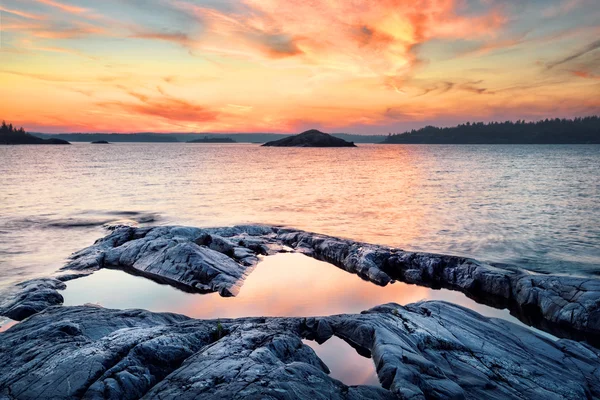 Stone pobřeží jezera při západu slunce — Stock fotografie