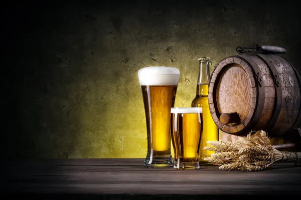 Glasses of beer with bottle and barrel — Stock Photo, Image