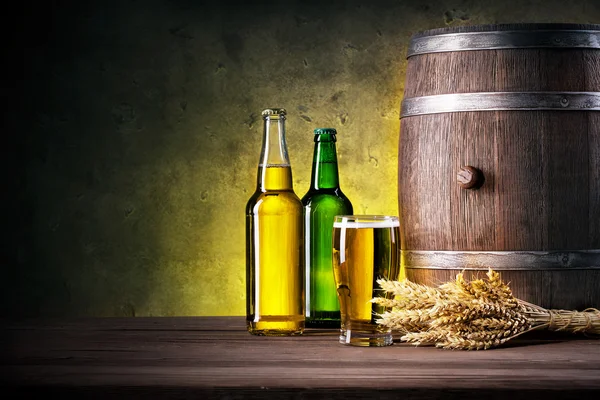 Full bottles of beer and glass with barrel — Stock Photo, Image