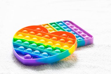 Popüler çocuklar anti-stresten oyuncaklar beyaz halıya sererler.