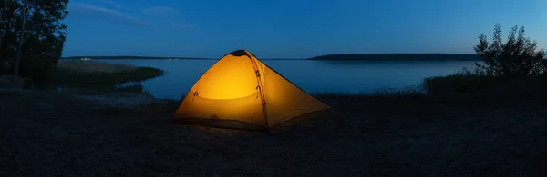 Barraca turística iluminada laranja no lago à noite — Fotografia de Stock
