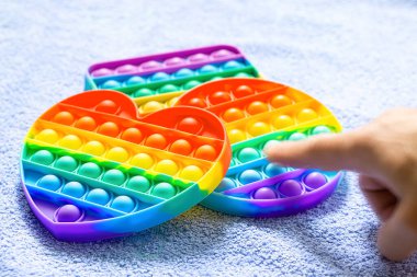 Moda çocukların oyuncakları anti-strese neden oluyor. İşaret parmağıyla mavi baloncukların üzerine koyuyorlar.