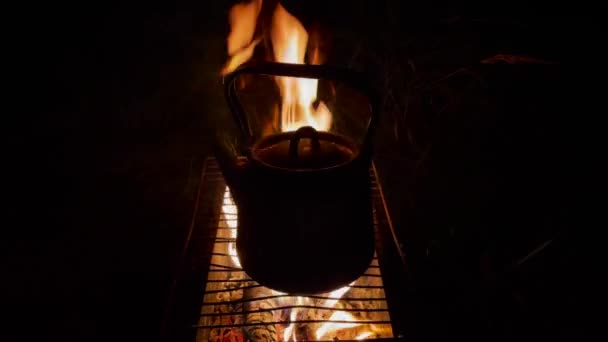 Chaleira em pé na fogueira no acampamento turístico à noite — Vídeo de Stock