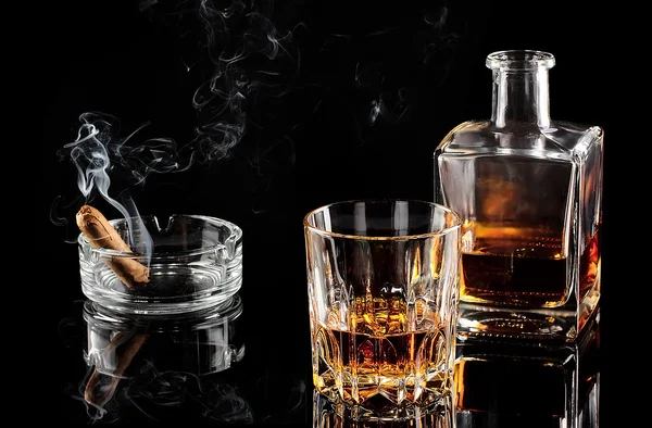 Glass of whiskey with ice, and a carafe of steaming cigar — Stock Photo, Image