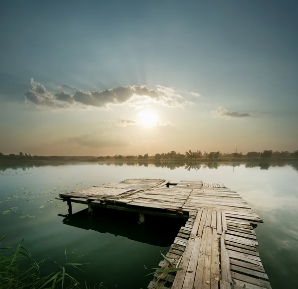 Amanhecer no lago com cais — Fotografia de Stock