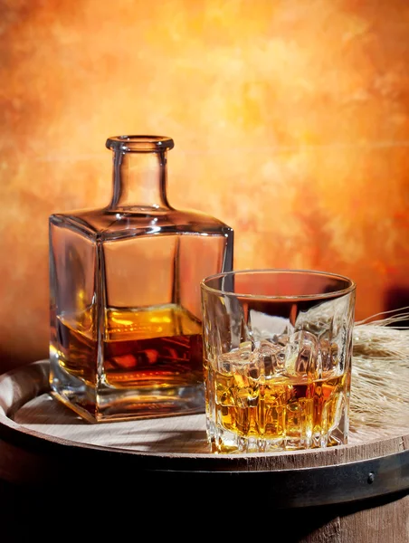 Láhve a sklenice whisky s ledem — Stock fotografie