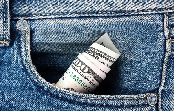 Rolado palha notas de cem dólares em seu bolso jeans — Fotografia de Stock
