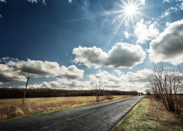 Strada di campagna asfaltata con una macchina di distanza — Foto Stock