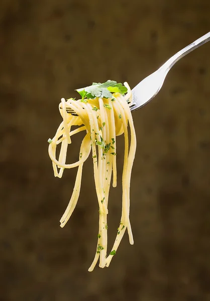 Spaghetti con foglie di prezzemolo ferite su una forchetta — Foto Stock