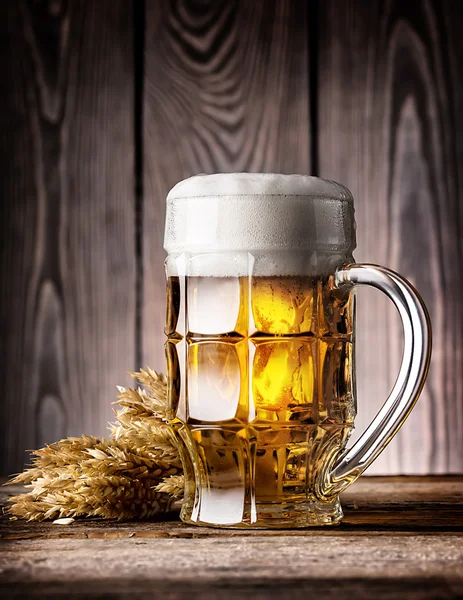 Faceted mug of light beer with foam and ears — Stock Photo, Image