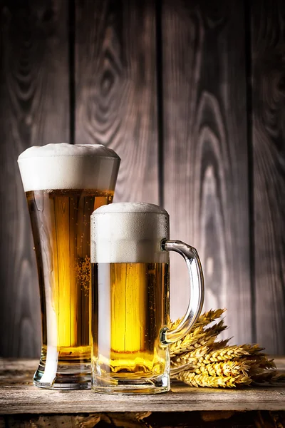 Glass and a mug of light beer with foam and ears — Stock Photo, Image