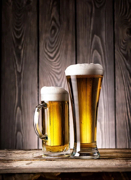 Groot glas en mok van light bier met schuim — Stockfoto