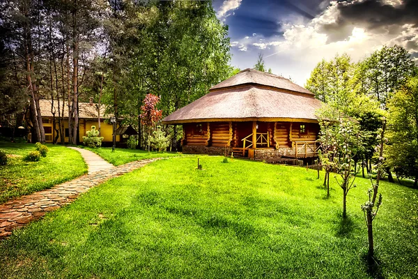 House of logs on the green lawn — Stock Photo, Image