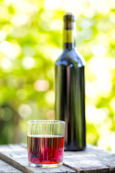 Garrafa e vinho tinto de vidro facetado — Fotografia de Stock