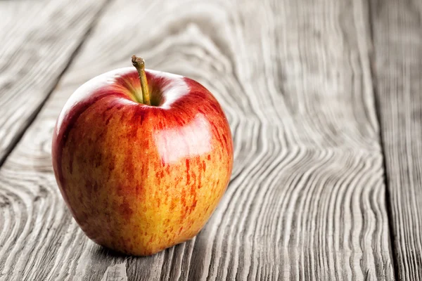 Red apple on a wooden table — Stock Photo, Image