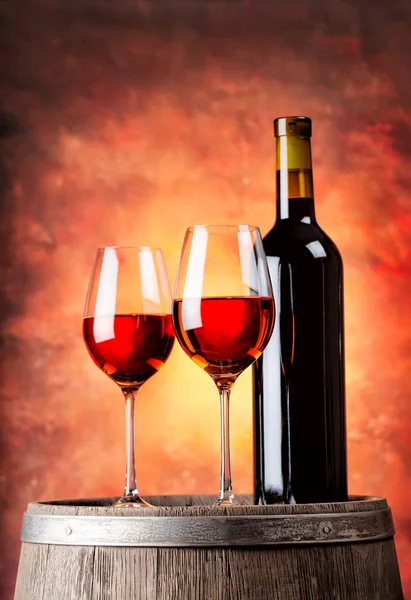 Botella de vino tinto y dos copas llenas — Foto de Stock