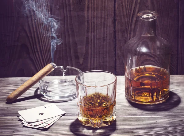 Cognac and cigar burning on a wooden table — Stock Photo, Image