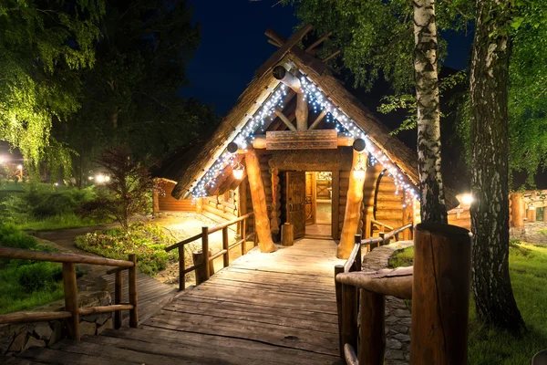 Holzhaus im Wald beleuchtet von Laternen — Stockfoto