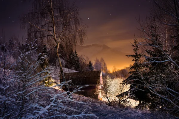 Casa iluminada na floresta de inverno — Fotografia de Stock