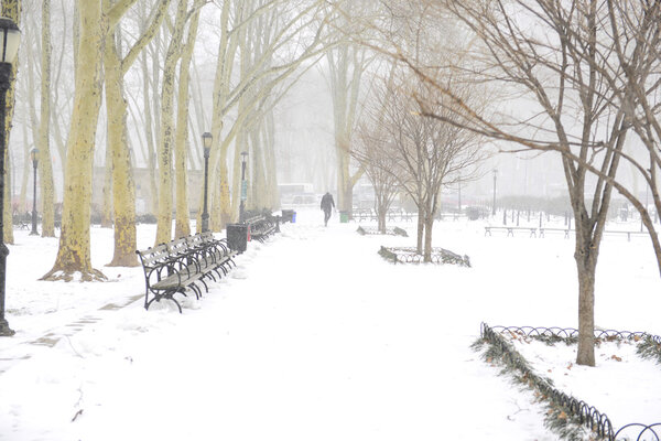 View of Cadman Plaza in Brooklyn Heights with snow accumulation & solitary figure in distant background