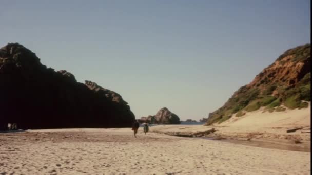 Man jaagt op vrouw op het strand — Stockvideo