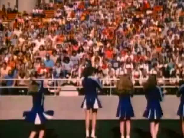 Cheerleaders facing spectators at football game — Stock Video
