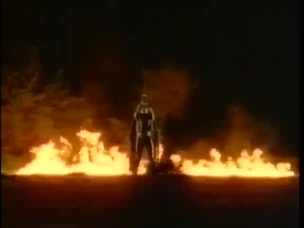 Persona de pie frente a las llamas — Vídeo de stock