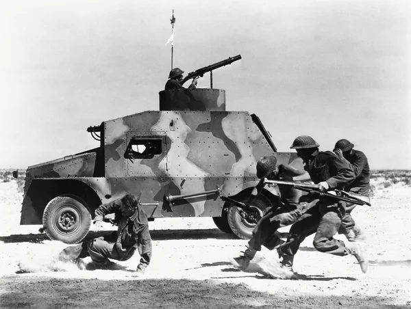 Soldati che corrono lungo il fianco del carro armato nel deserto — Foto Stock