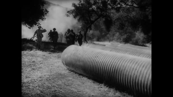 Soldiers running into large tubes — Stock Video