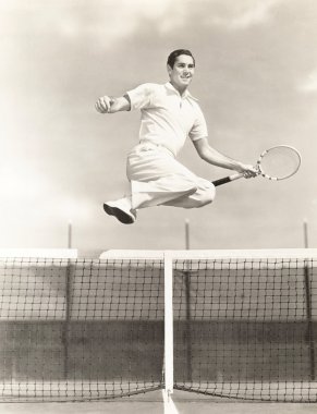 Genç adam tenis oynuyor.