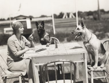 köpeklerle masada oturan kadın