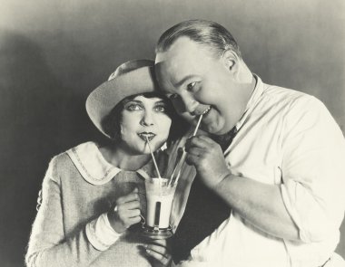 man and  woman Sharing a milkshake clipart