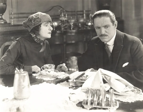 Homme et femme assis à table — Photo