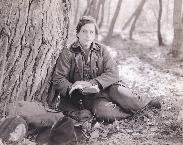 Uomo che legge nel bosco — Foto Stock