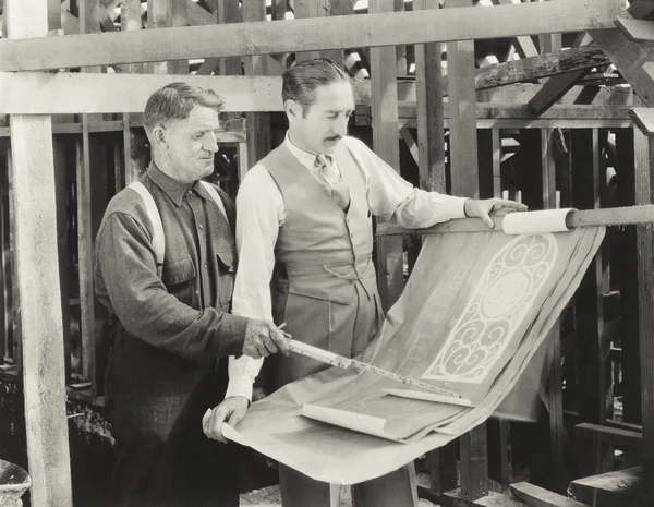 Bouwvakker gaan over plannen — Stockfoto