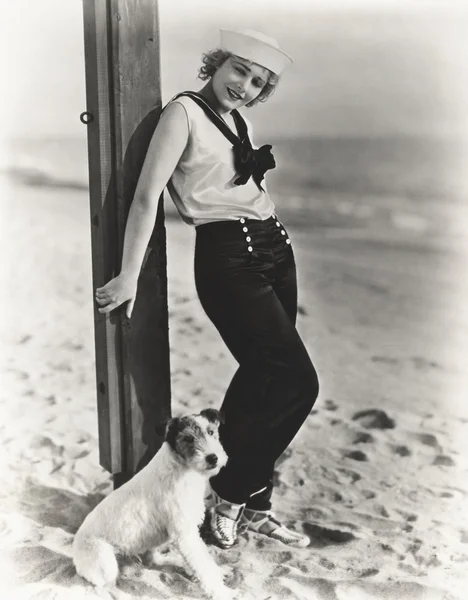 Young woman and dog on beach Royalty Free Stock Photos