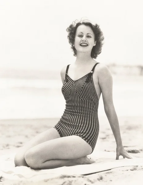 Mujer joven sentada en la playa Imagen de archivo