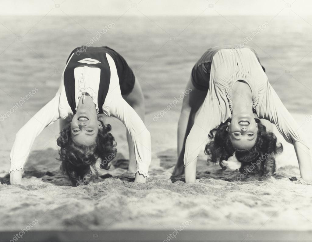 women doing backbends on the beach