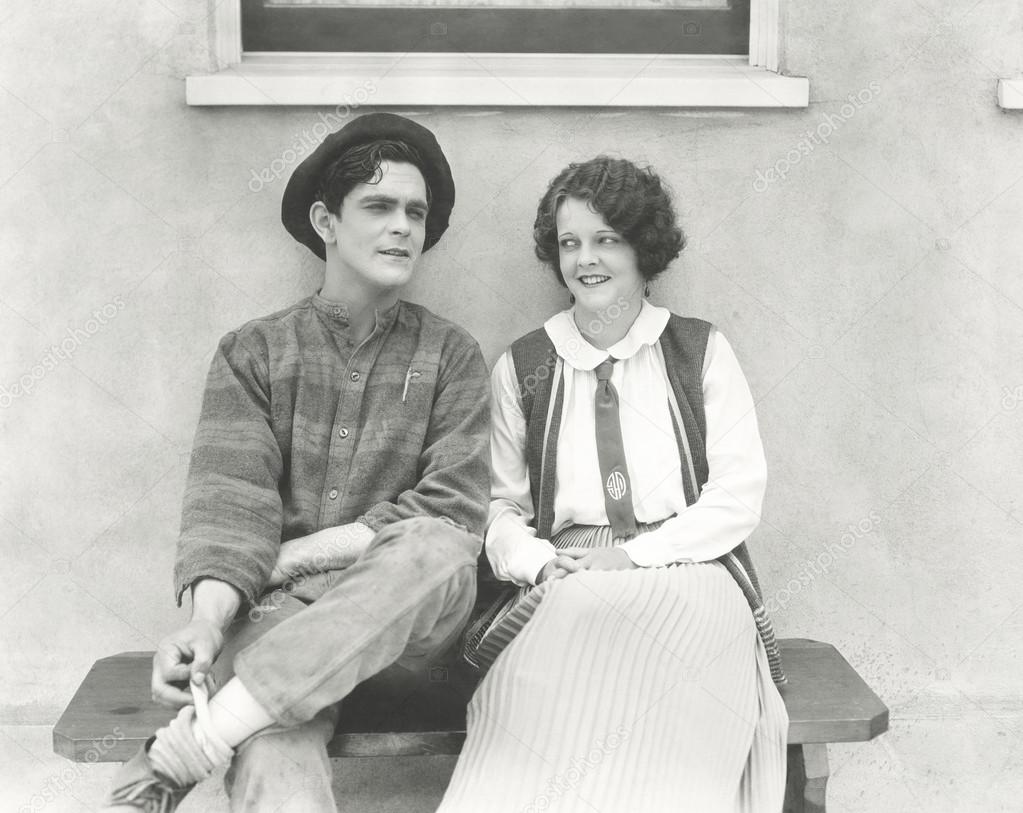 Young man and woman sitting outdoors